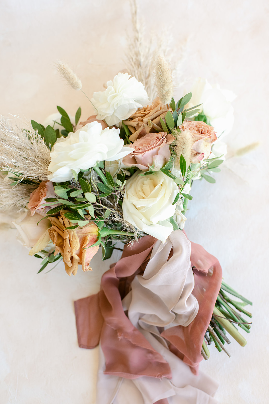 Organic wedding bouquet with neutral tones and delicate flowers photographed on wedding day