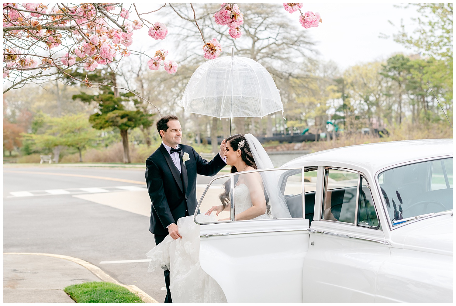 pretty cherry blossom moment in the rain with bride and groom