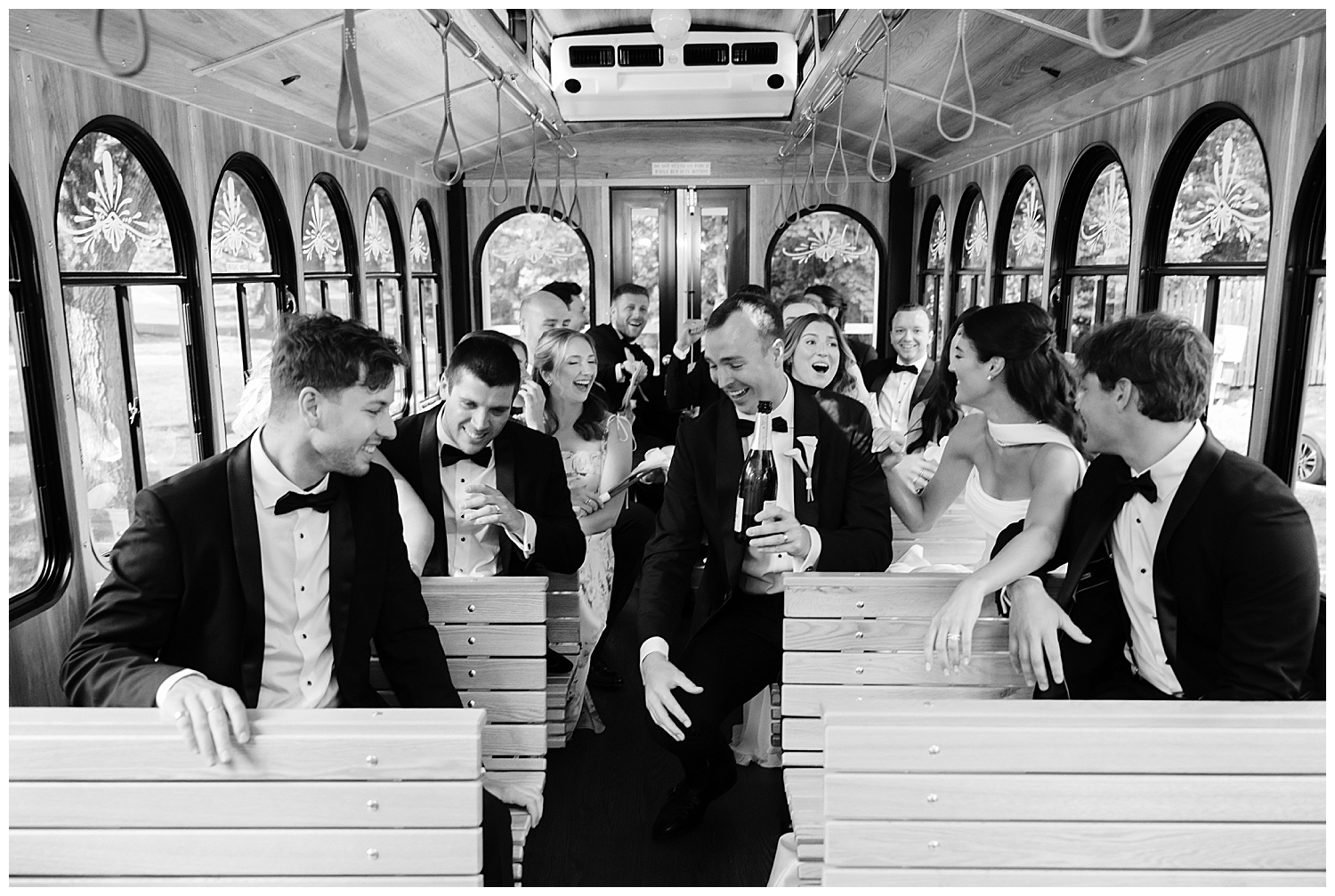 bridal party popping a bottle of champagne on the wedding trolley
