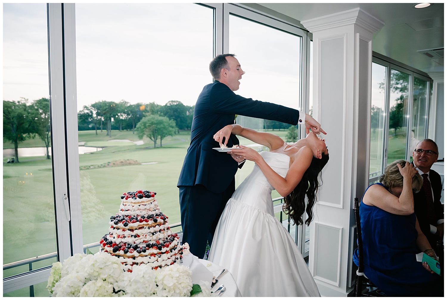 bride and groom having a blast covering each others noses with wedding cake