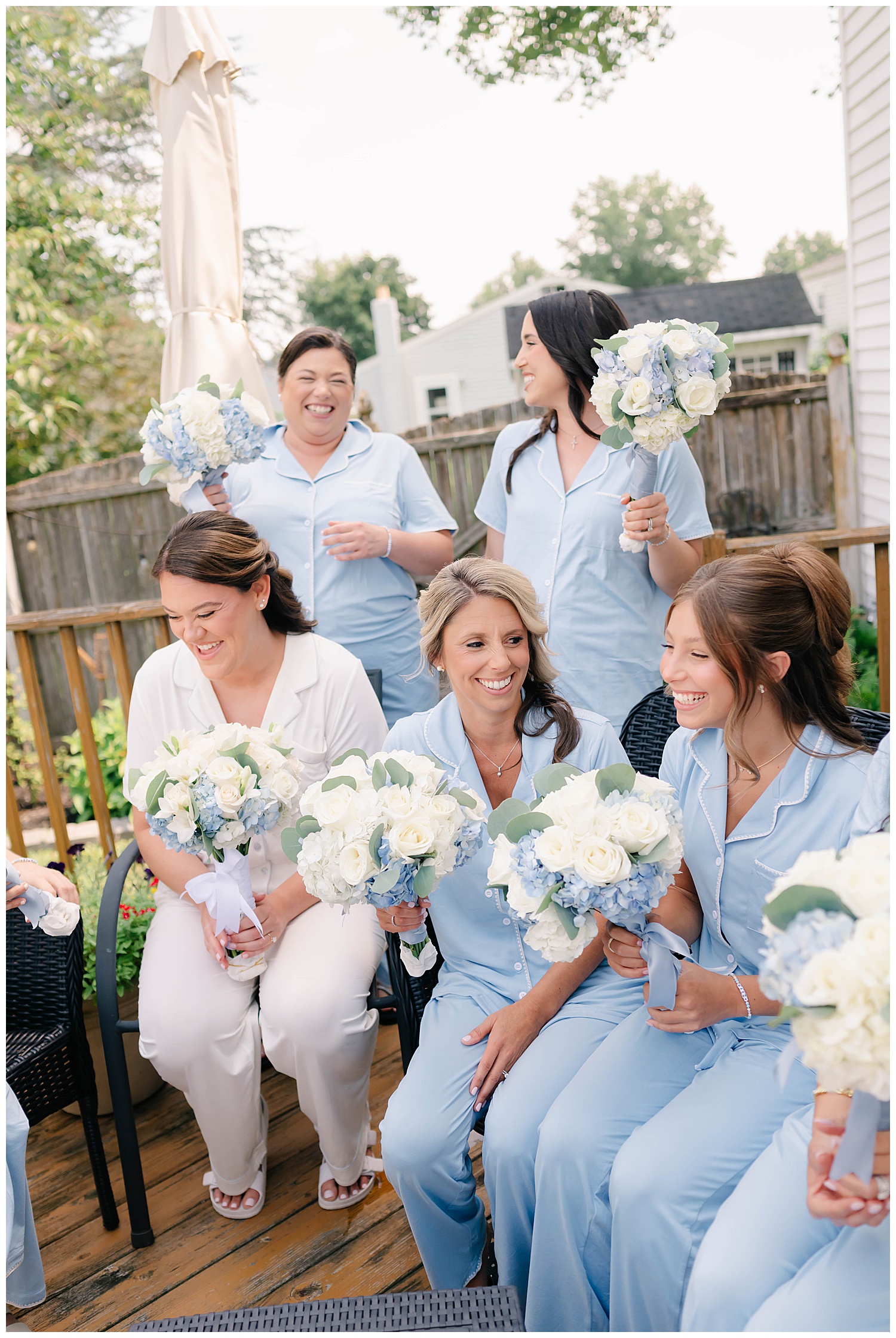 bride and bridesmaids having a laugh on the patio in blue pajamas