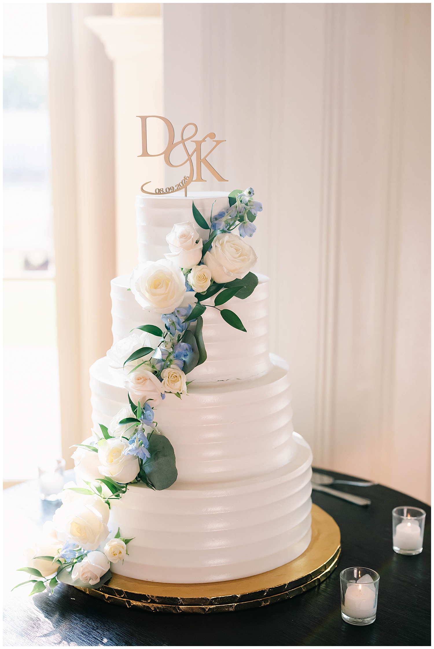 four layer wedding cake decorated with blue hydrangeas