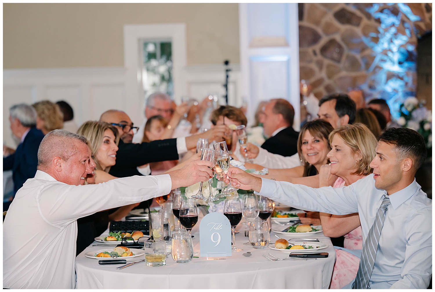 reception photo of everyone cheering and raising their glasses