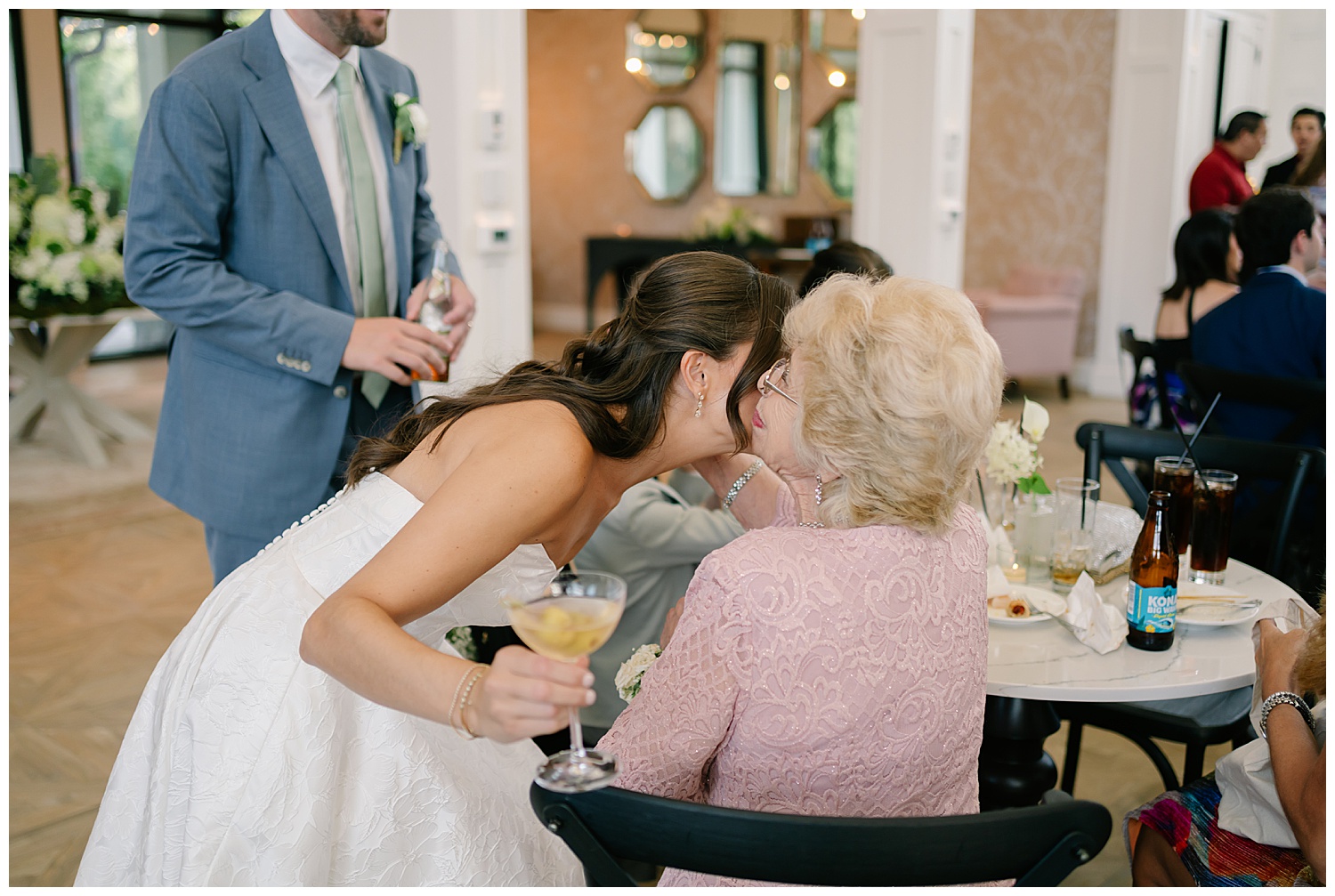 bride kissing grandmother at reception